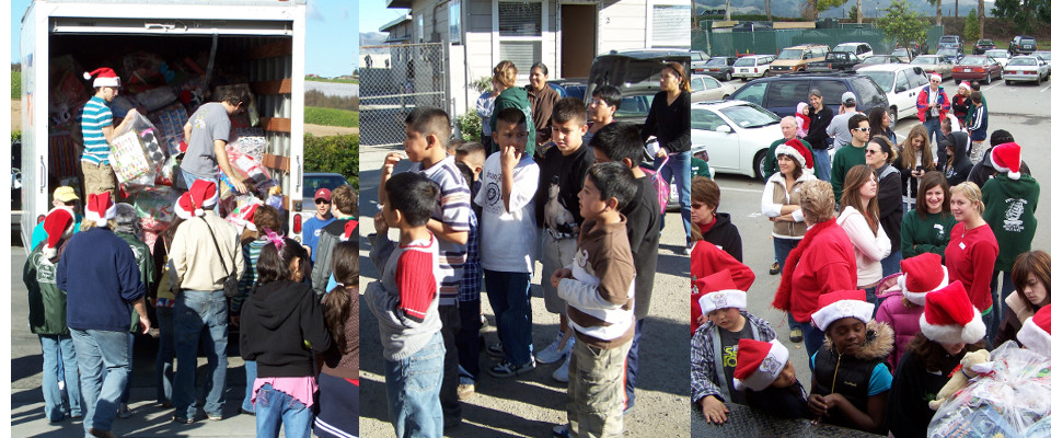 Volunteers unloading a truck full of wrapped gifts as children gather for the delivery